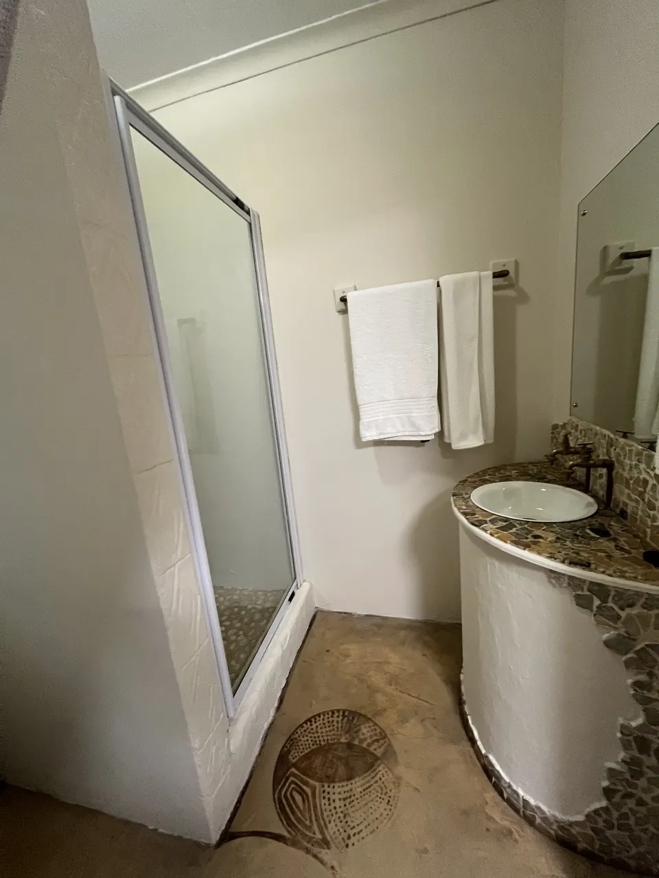 Bathroom with pebble mosaic basin and fresh white towels