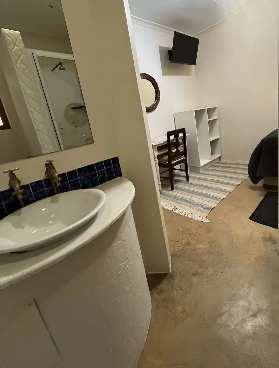 Curved vanity with vessel basin and blue tile splashback