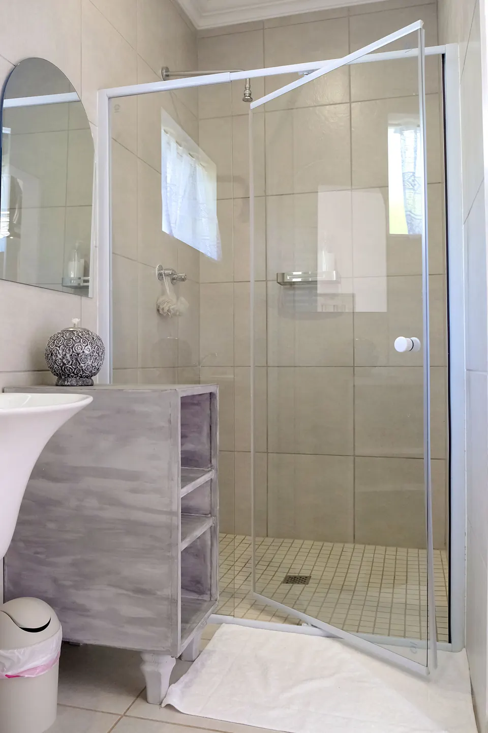 Tiled walk-in shower with fresh white bathmat