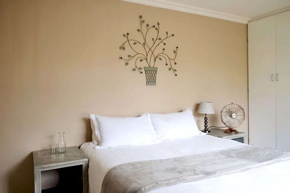 Double room with white linen and botanical wall art