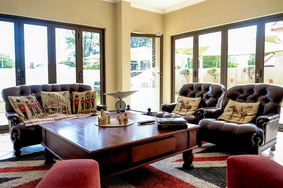 Guest lounge with chesterfield leather sofas, cushions and folding glass doors