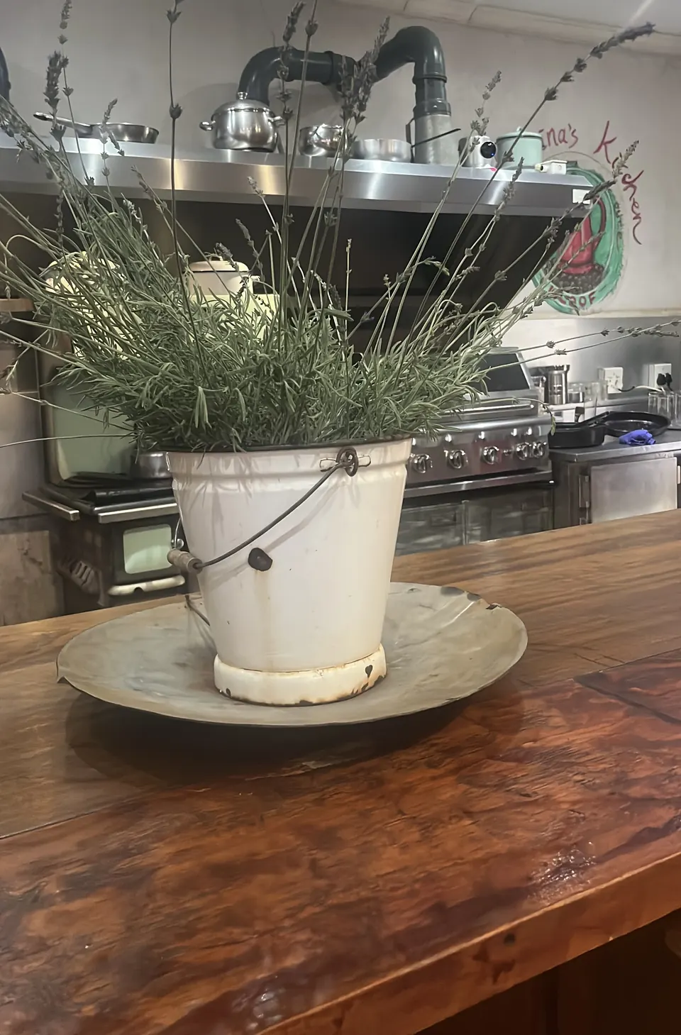 Enamel bucket of lavender on a wooden kitchen counter