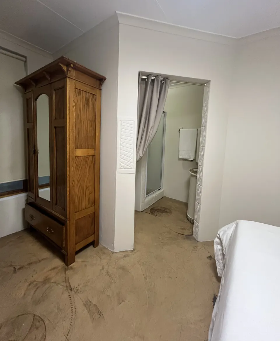 Guest room with oak wardrobe and curtained en-suite shower