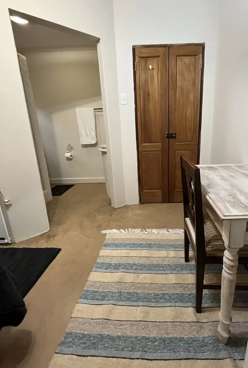 Single room entrance with timber doors, desk and striped rug