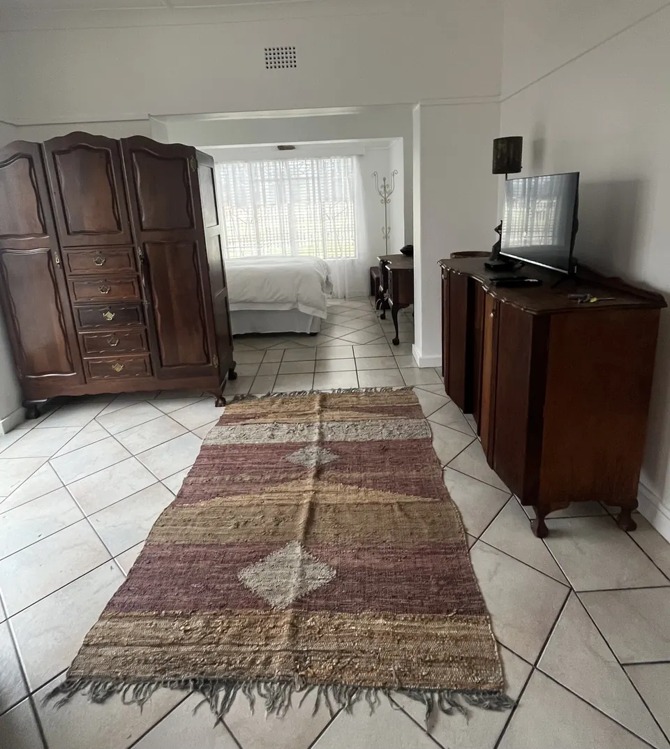 Two-bedroom unit with antique wardrobe, chest of drawers and woven runner