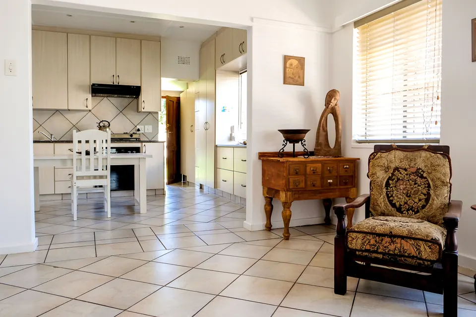 Open-plan kitchen and lounge in the two-bedroom unit with antique chest and carved sculpture