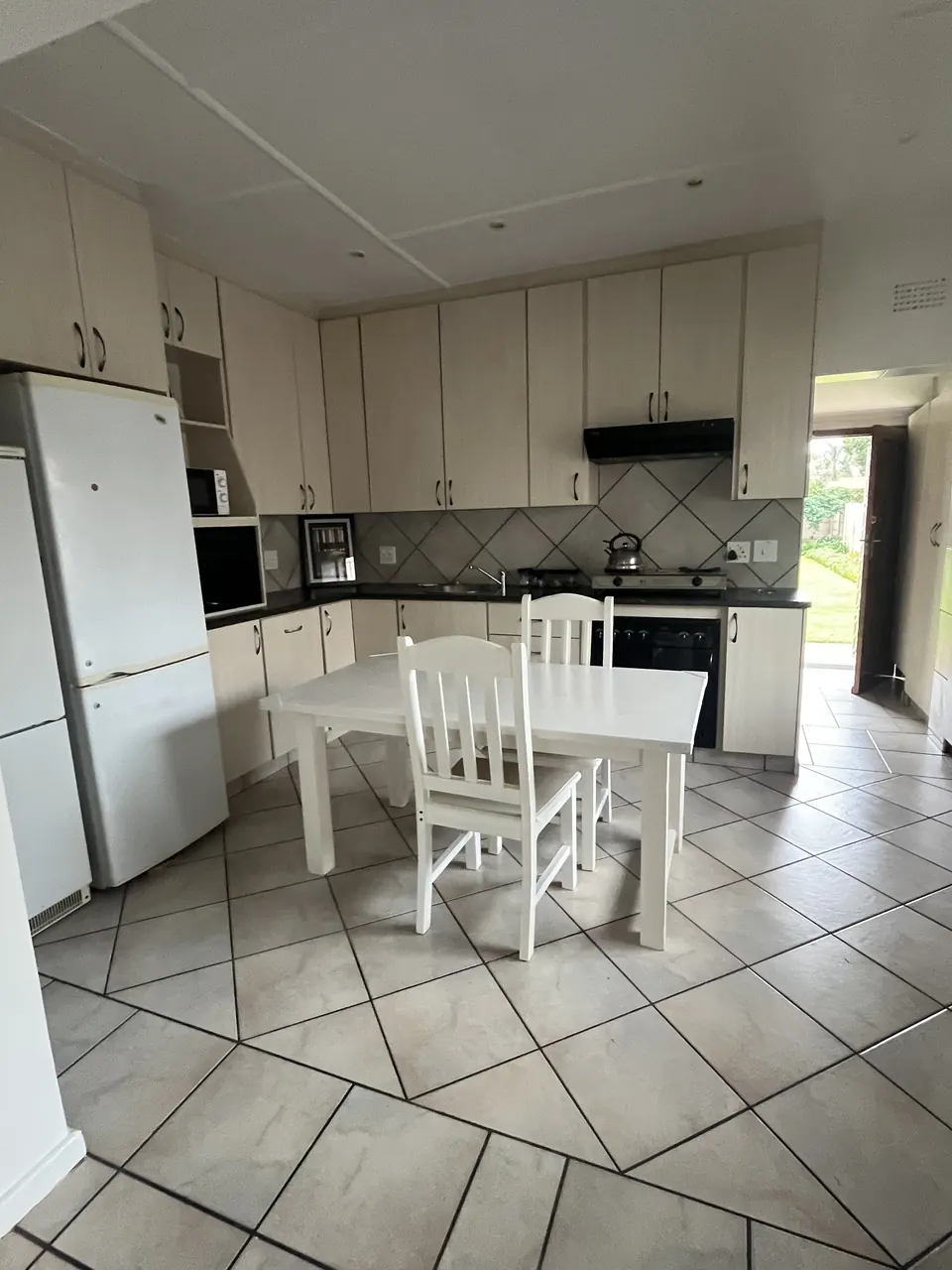 Kitchen with white table and chairs in the two-bedroom unit