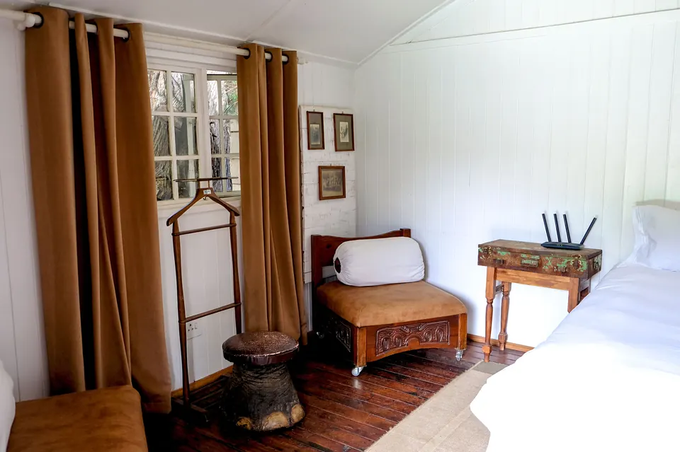 Wood-panelled guest room with amber curtains and vintage furniture